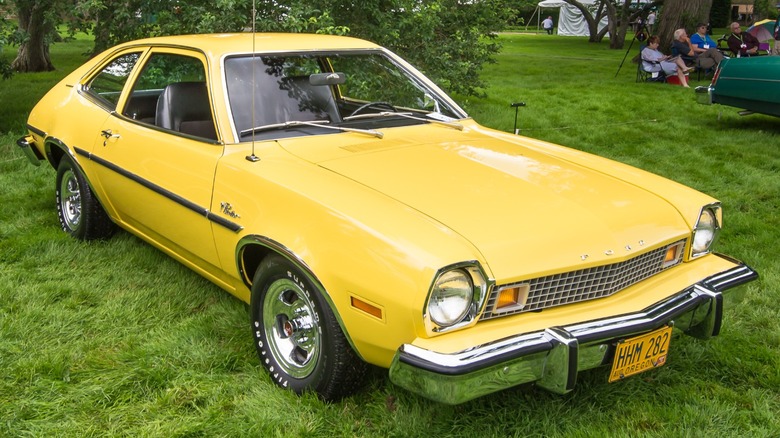 a Yellow Ford Pinto parked on the grass