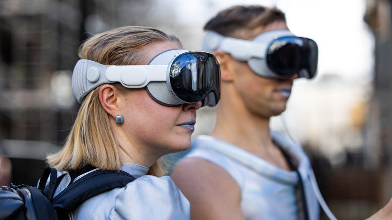 Two people, both wearing an Apple Vision Pro headset, during Fashion Week 2024