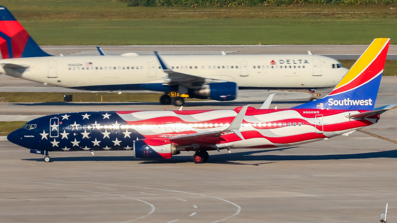 Southwest's Freedom One jet on a runway with a Delta jet behind it.