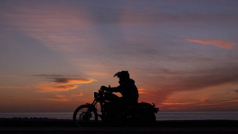 biker riding with the setting sun behind them