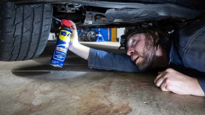 Person using WD-40 on car