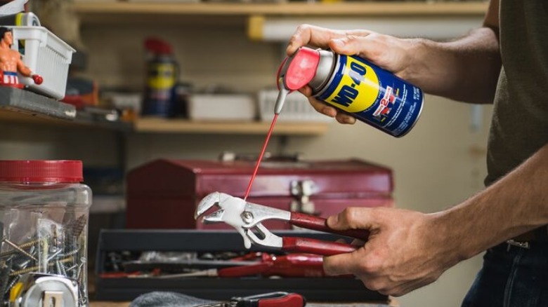 Person using WD-40 on wrench