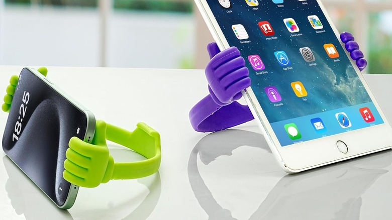 Apple devices held by hands-themed stand