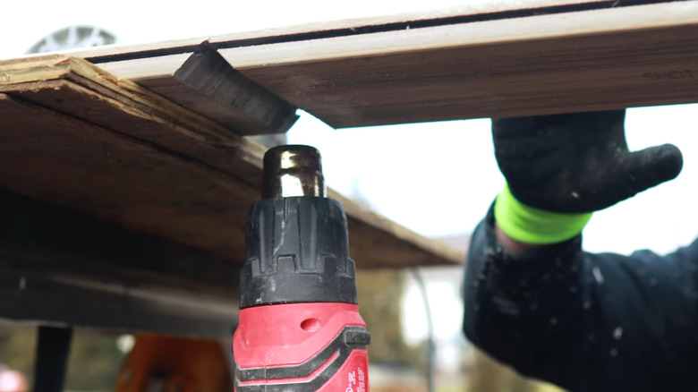 Heat gun being used to dry and bend wood.