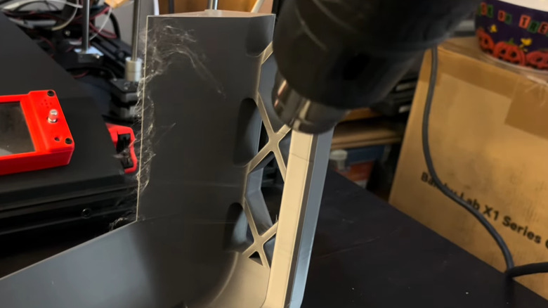 heat gun being used to remove string from 3D print