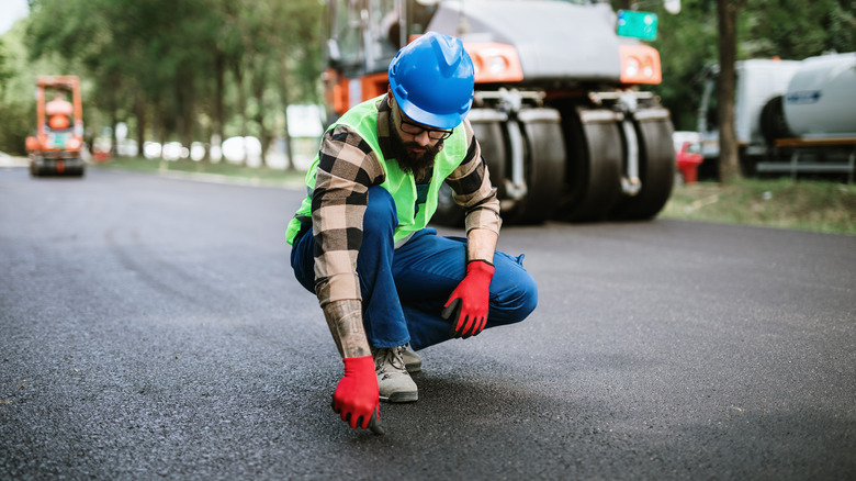 construction worker inspecting the road