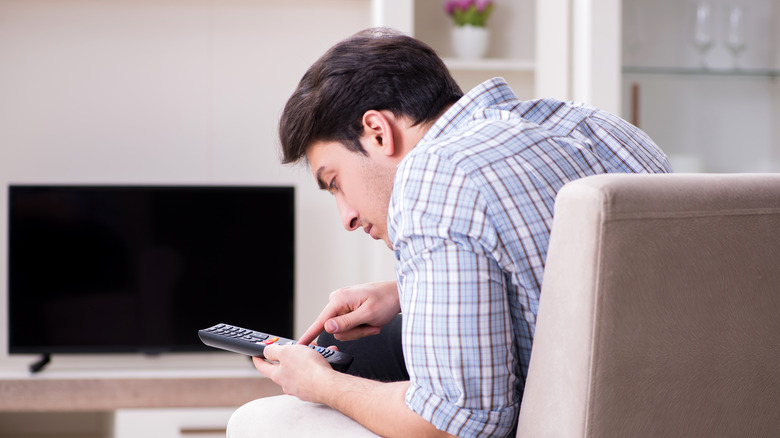 Man inspecting TV remote