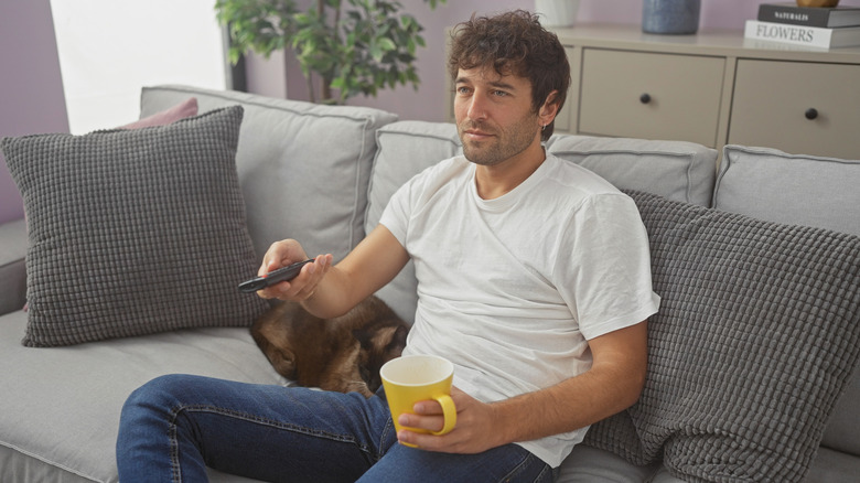 Man pointing remote at TV