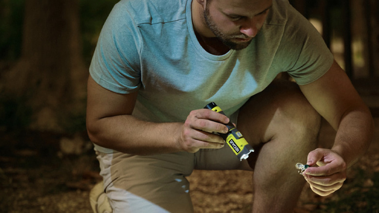 person using Ryobi flashlight