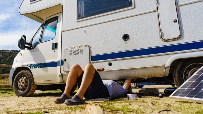 Person working on an RV with tools