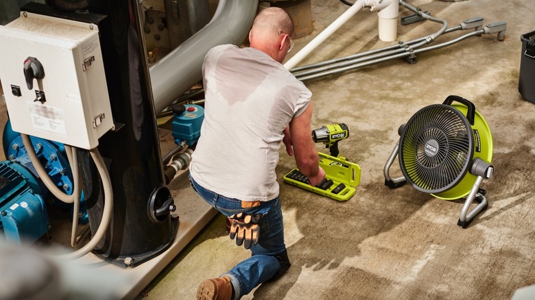 person with ryobi 40v fan working on floor