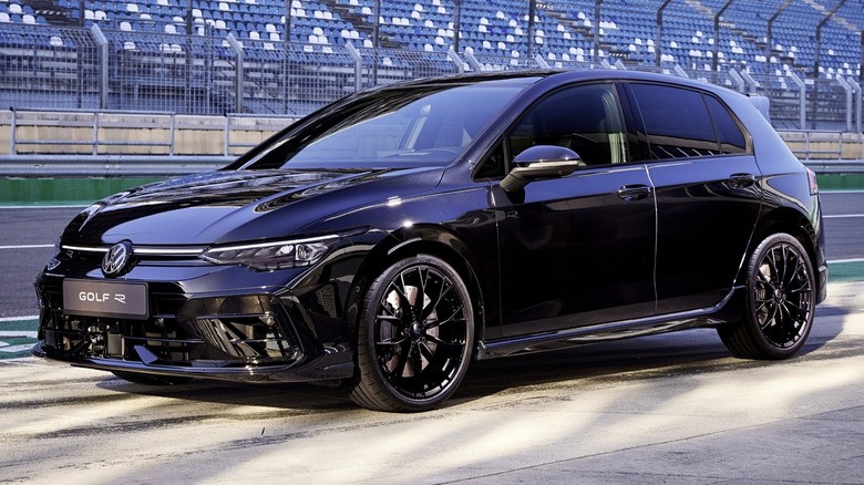 Volkswagen Golf R Black Edition parked on a paved surface with grandstands in the background