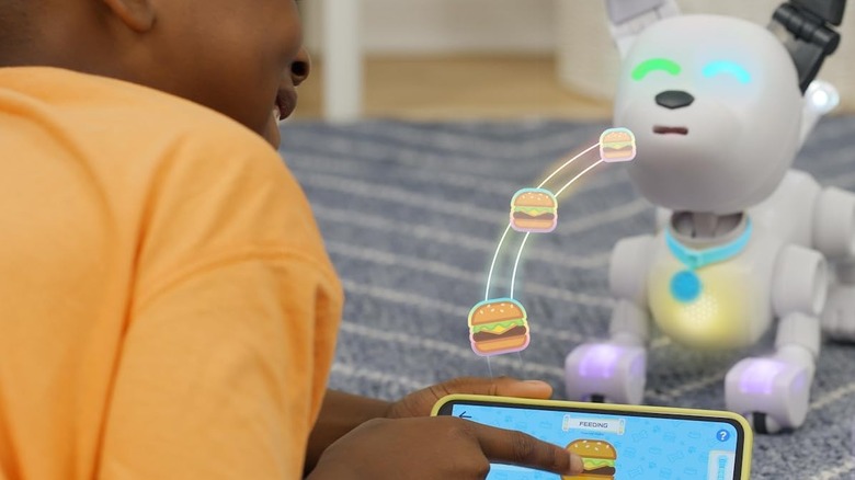 Child pressing giving dog robot virtual treats