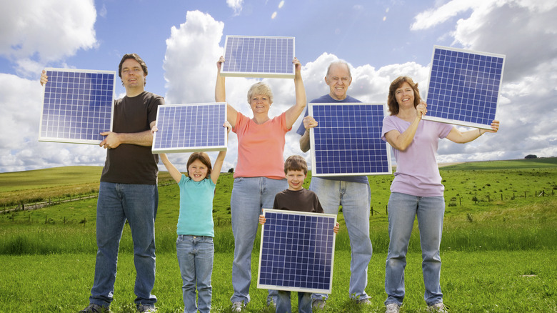 group holding solar panels