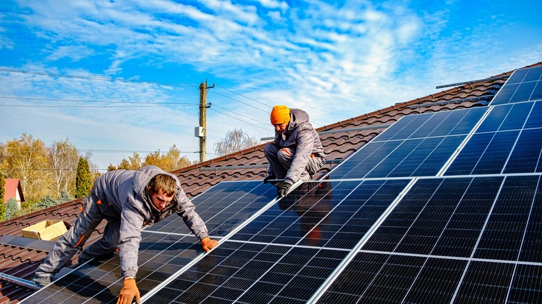 solar installers on a roof