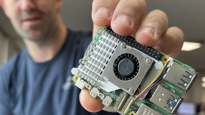 Man holding a Raspberry Pi 5 with Active Cooler