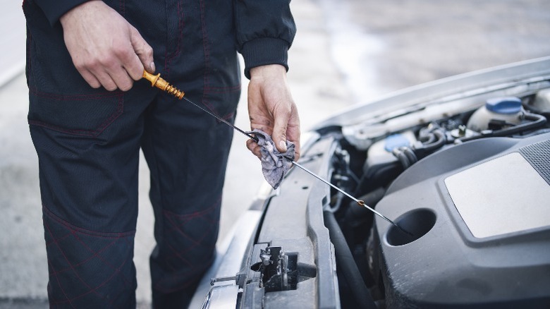 person checking oil dipstick