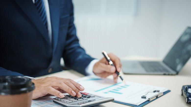 A person using calculator to calculate insurance