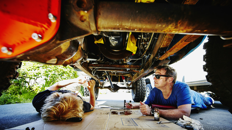 Father and son below their car