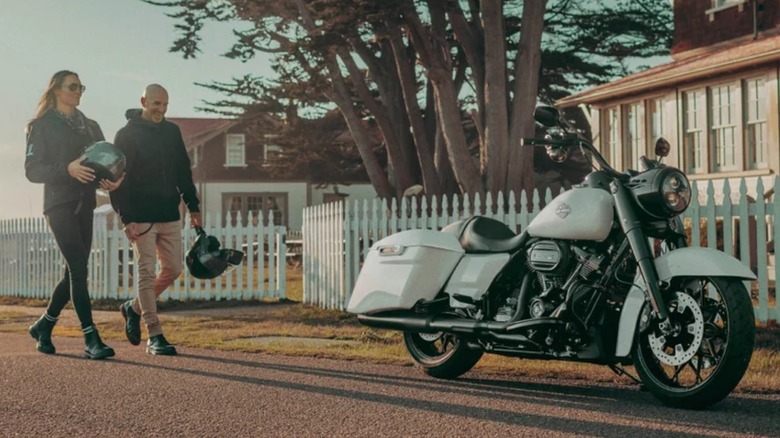 People walking toward Harley motorcycle