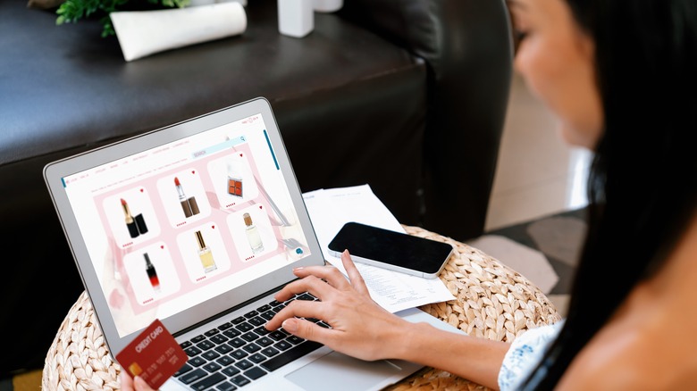 woman using credit card with laptop