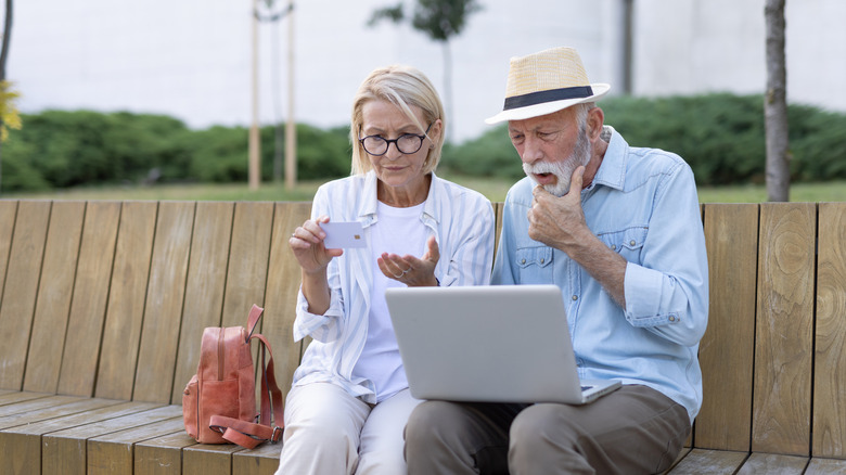 elderly couple buying online on laptop