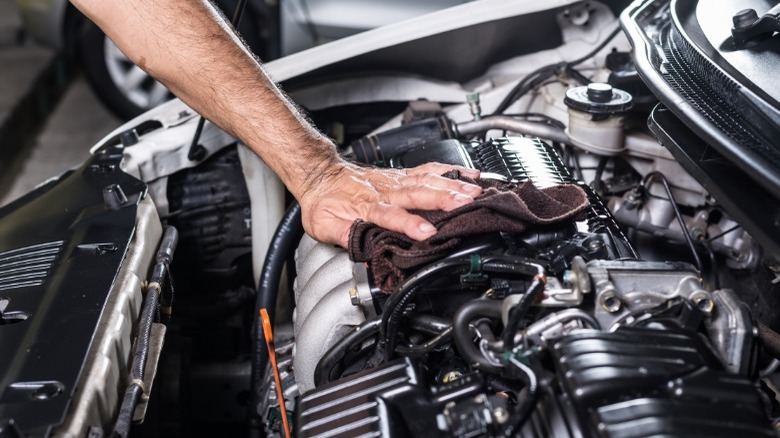 person cleaning an engine