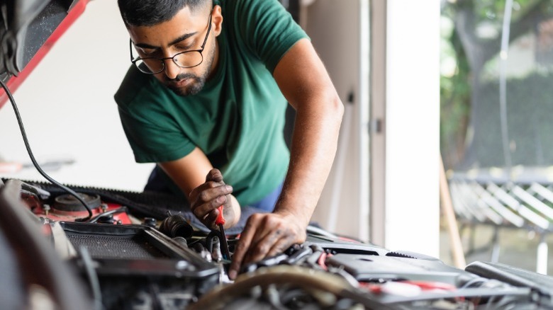 person working on car engine