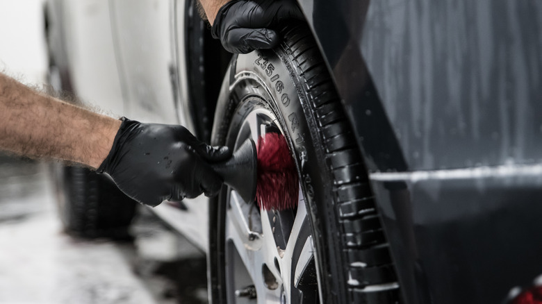 person cleaning car wheels