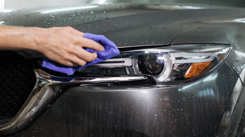 person cleaning care headlights