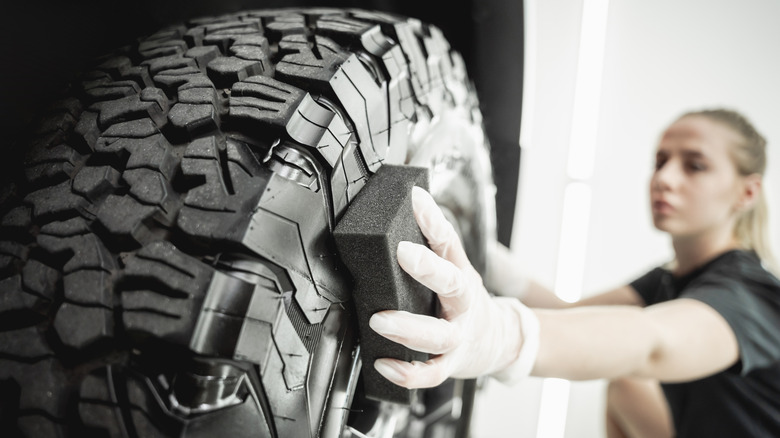 Woman scrubbing her tire with sponge