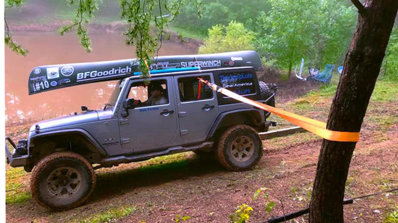 Jeep with tow strap tied to tree