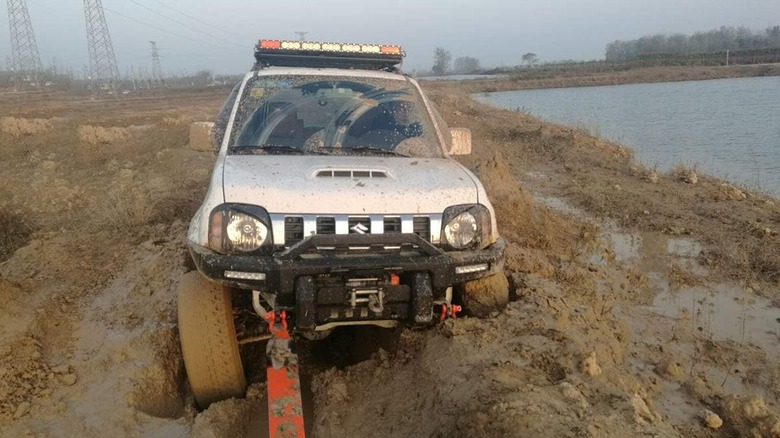 a car being pulled by tow straps through mud