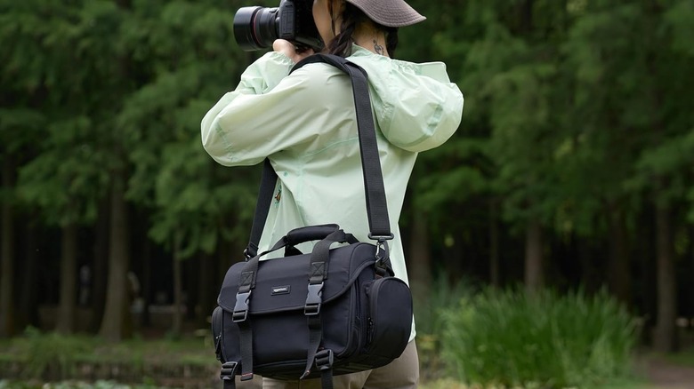 Woman taking photos with Amazon Basics DSLR gadget camera sling