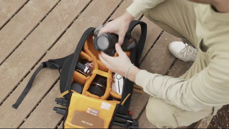 Man taking camera out of a Tarion camera backpack