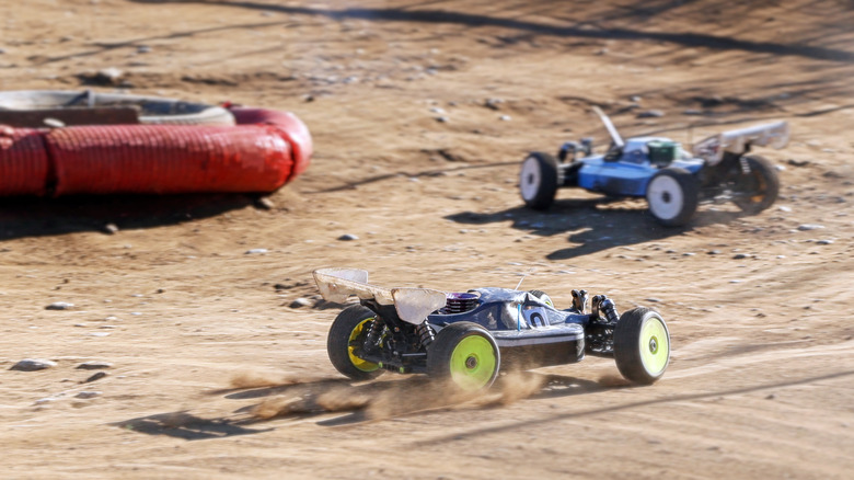 Two RC cars racing on dirt