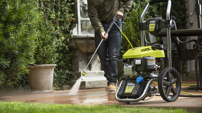 person using ryobi pressure washer