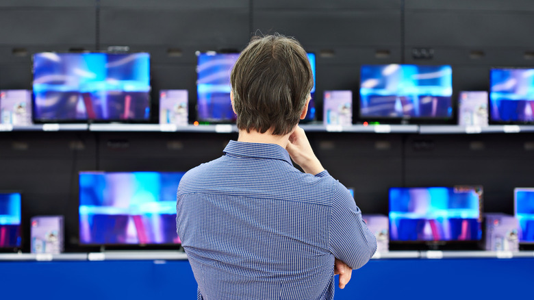 Person examining TVs in store