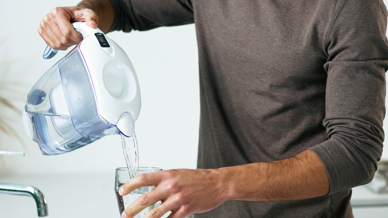 man using water filter pitcher