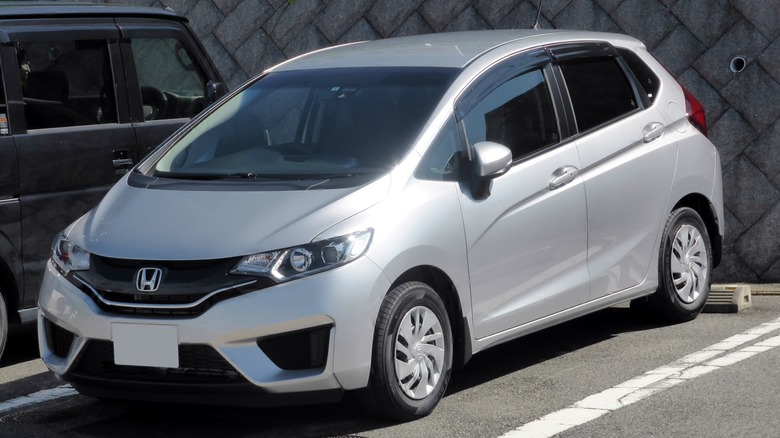 silver Honda Fit 13G backed into parking space