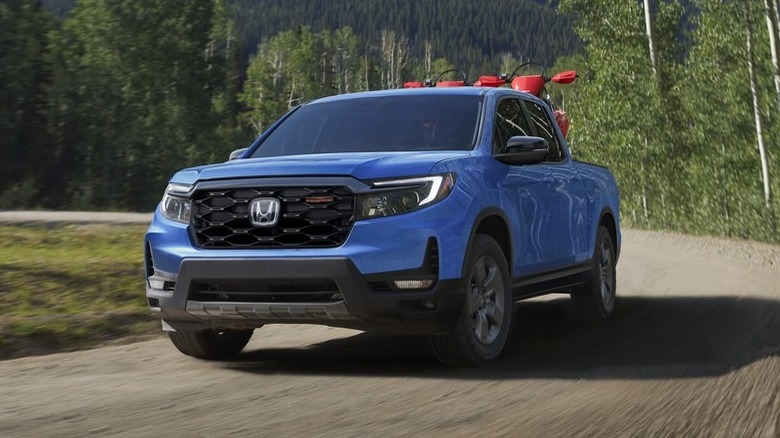 blue 2024 Honda Ridgeline TrailSport driving on dirt road