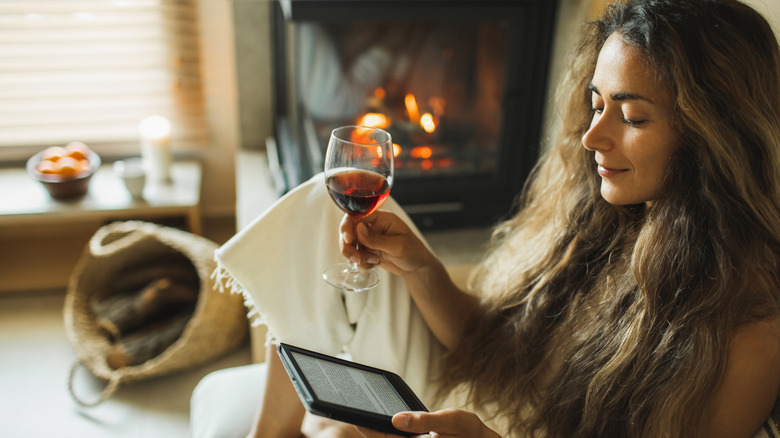 woman reading on Kindle with wine glass