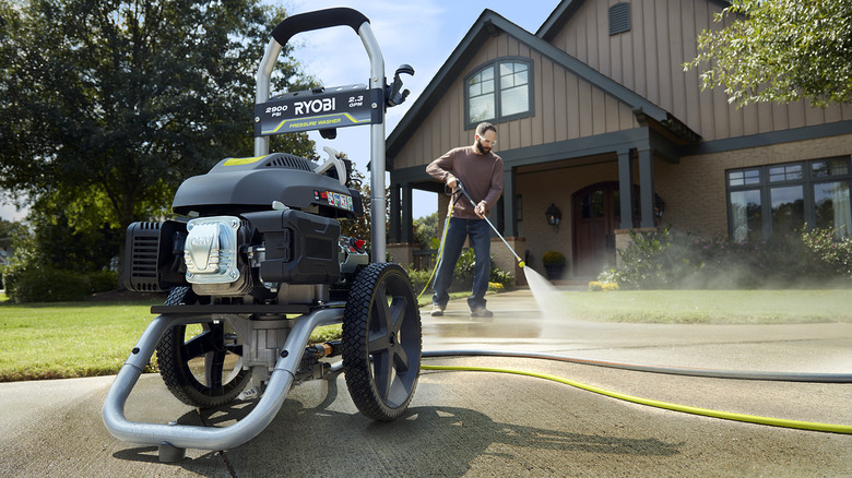 person using 35-foot hose with Ryobi pressure washer in foreground