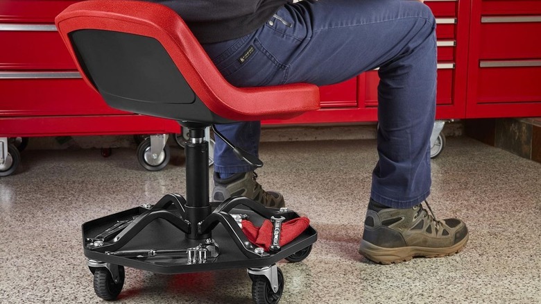 Person sitting in an Icon Professional Adjustable Shop Seat with Tool Storage