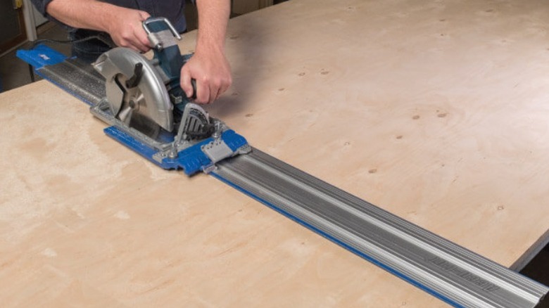 Person using track saw with Kreg KMA3700 Accu-Cut XL Track Saw Guide on plywood