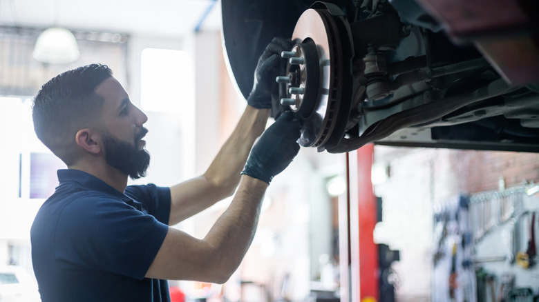 Person checks brake disk of vehicle