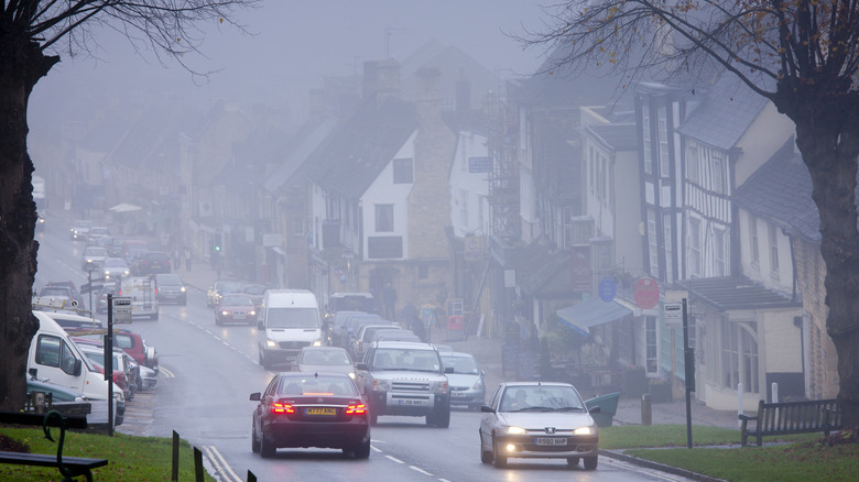 Vehicles driving down a misty road