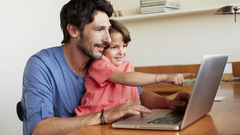 Dad and kid looking at laptop