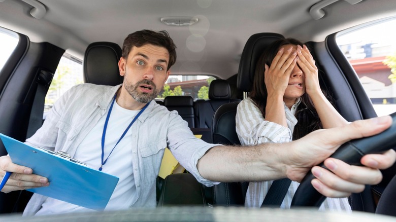 Driving instructor helping distressed student