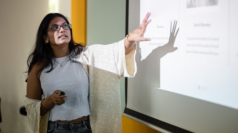 student presenting in front of projector screen